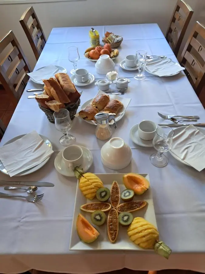La table du petit déjeuner, avec le pain, les viennoiseries et les fruits frais